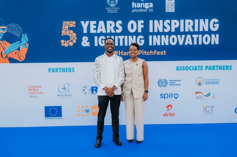 Two men posing on a blue stage at a 5 Years of Inspiring & Igniting Innovation event with sponsor logos displayed behind them.